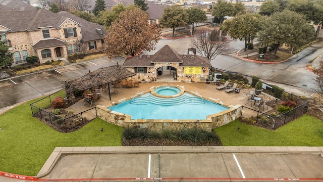 view of pool featuring a community hot tub, a patio area, and a lawn