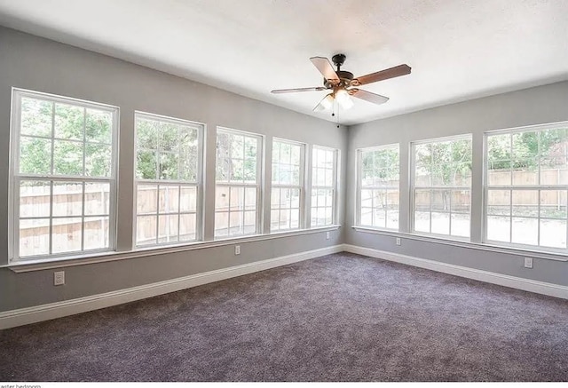 unfurnished sunroom with ceiling fan