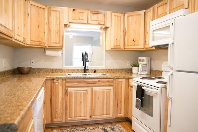 kitchen with white appliances, light brown cabinetry, and sink