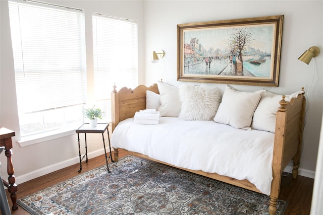 bedroom with multiple windows and dark wood-type flooring