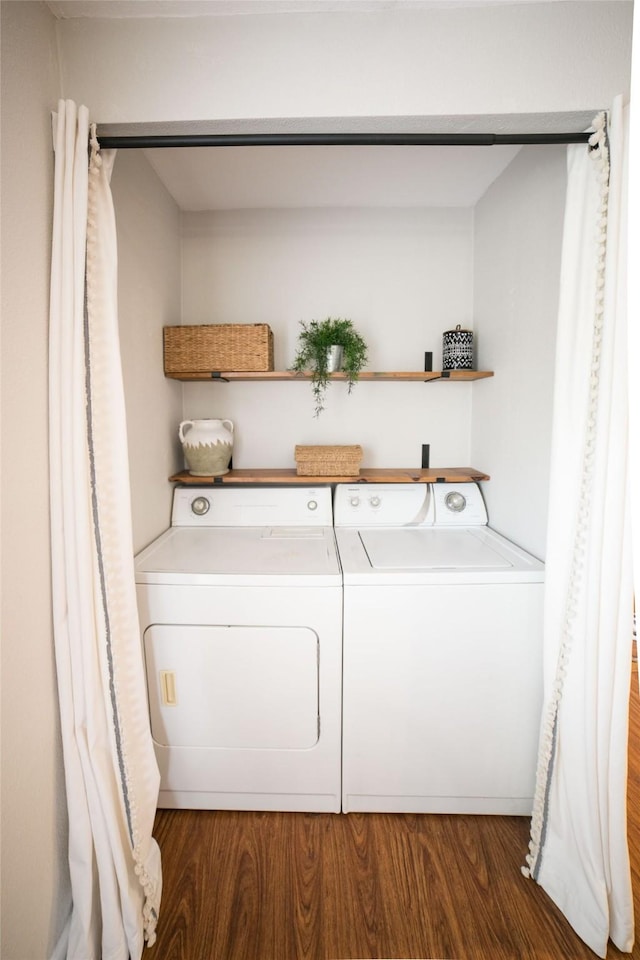 washroom with dark wood-type flooring and washing machine and dryer