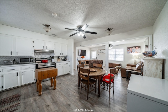 kitchen with white cabinetry, appliances with stainless steel finishes, wood-type flooring, and backsplash