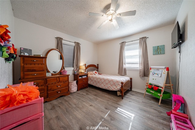 bedroom featuring wood-type flooring, ceiling fan, and a textured ceiling