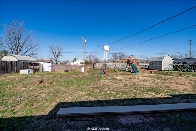 view of yard with a storage shed and a playground