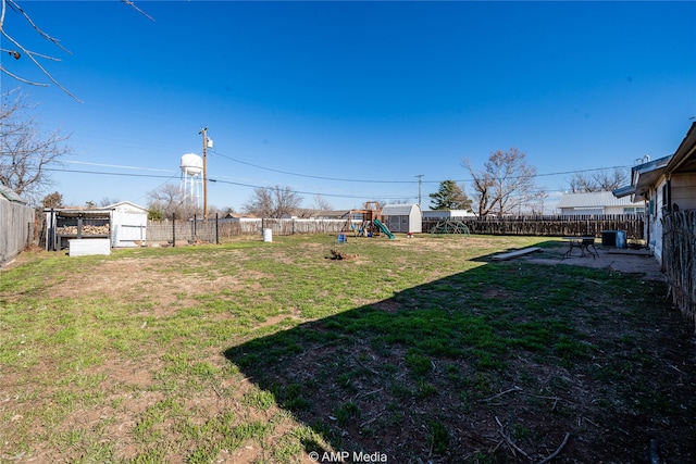 view of yard featuring a playground, central AC unit, and a storage shed