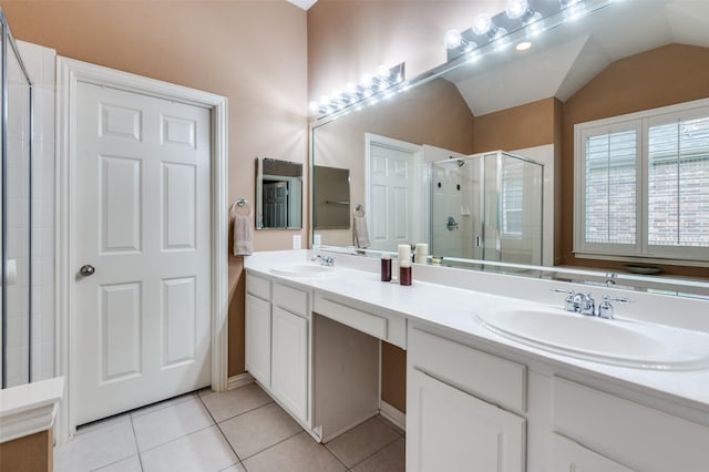 bathroom with a shower with shower door, vanity, tile patterned flooring, and vaulted ceiling