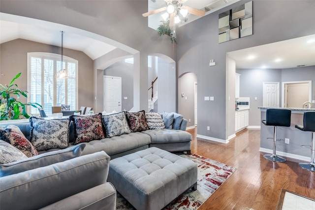 living room featuring lofted ceiling, hardwood / wood-style floors, and ceiling fan