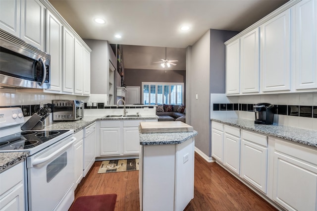 kitchen featuring sink, white appliances, dark wood-type flooring, and white cabinets