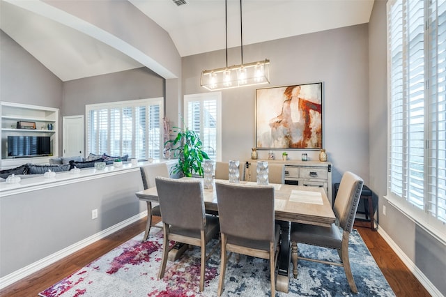 dining area with dark hardwood / wood-style flooring, vaulted ceiling, and plenty of natural light