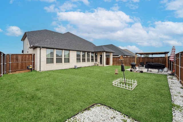 back of property featuring brick siding, a yard, a patio, roof with shingles, and a fenced backyard