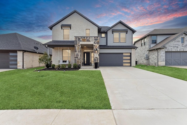 view of front facade with driveway, a garage, a balcony, a front lawn, and brick siding