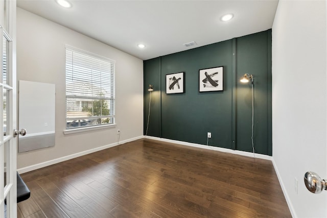 empty room featuring baseboards, visible vents, dark wood-type flooring, and recessed lighting