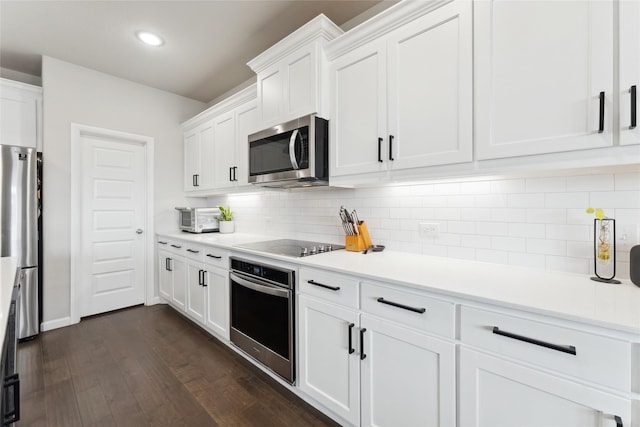 kitchen with dark wood-style floors, white cabinetry, stainless steel appliances, and light countertops