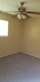 unfurnished room featuring a textured ceiling and ceiling fan