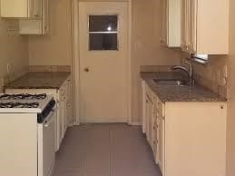 kitchen featuring sink, light tile patterned floors, and white range with gas cooktop