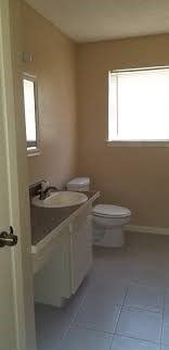 bathroom with a healthy amount of sunlight, toilet, tile patterned flooring, and vanity