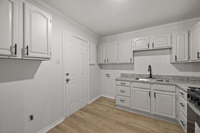 kitchen with white cabinetry, sink, ornamental molding, stainless steel range, and light wood-type flooring