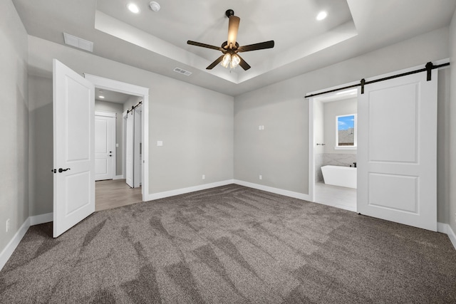 422 Collum Vw, Azle, TX 76020 - unfurnished bedroom with carpet floors, a tray ceiling, a barn door, baseboards, and recessed lighting