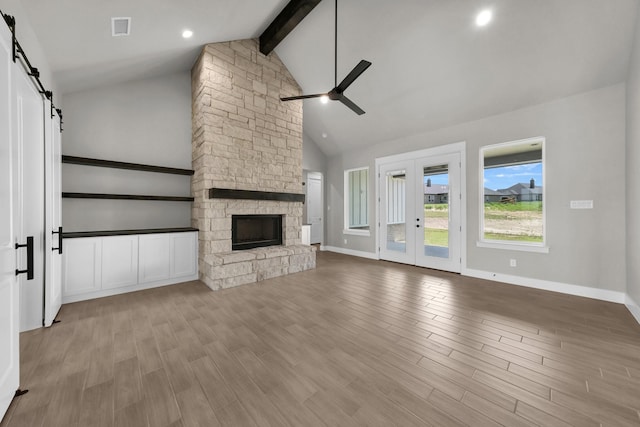422 Collum Vw, Azle, TX 76020 - unfurnished living room featuring a barn door, a ceiling fan, beamed ceiling, wood finished floors, and high vaulted ceiling