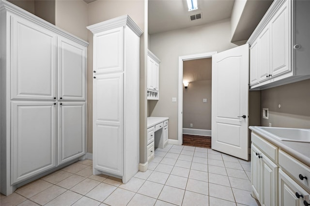 105 Zephyr Ct, Aurora, TX 76078 - kitchen featuring a sink, light tile patterned floors, light countertops, baseboards, and white cabinets