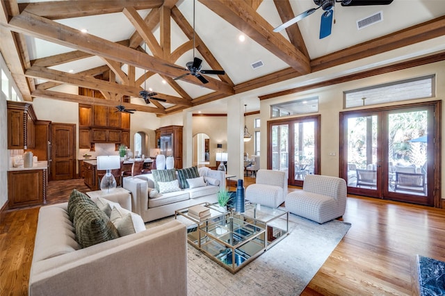 living room featuring beam ceiling, high vaulted ceiling, ceiling fan, and light hardwood / wood-style flooring