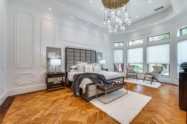 bedroom featuring light parquet flooring, ornamental molding, an inviting chandelier, and a towering ceiling