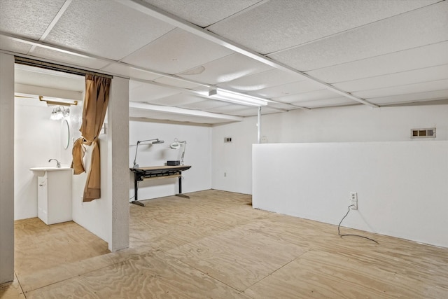 basement with a paneled ceiling