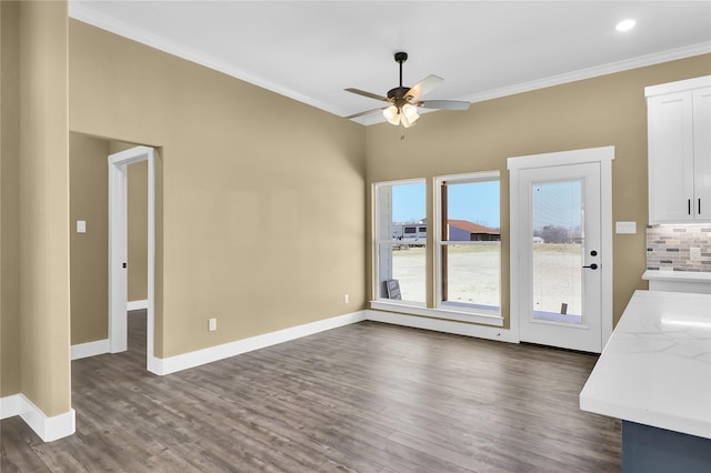 unfurnished living room featuring crown molding, ceiling fan, and dark wood-type flooring