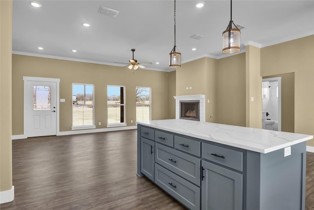 kitchen featuring crown molding, decorative light fixtures, a wealth of natural light, and a center island