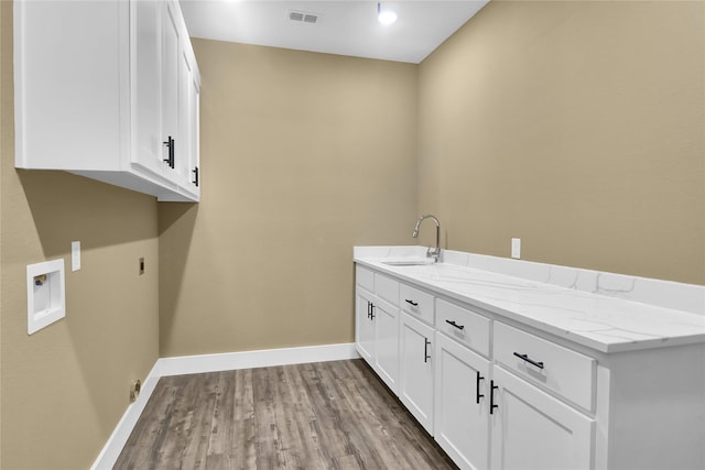 clothes washing area featuring sink, cabinets, washer hookup, light hardwood / wood-style floors, and hookup for an electric dryer