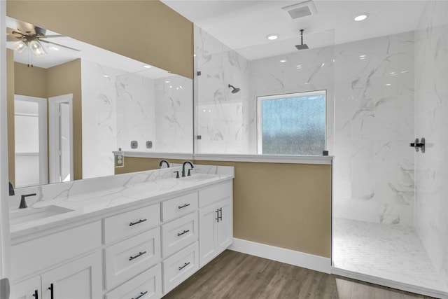 bathroom featuring ceiling fan, vanity, hardwood / wood-style floors, and a tile shower