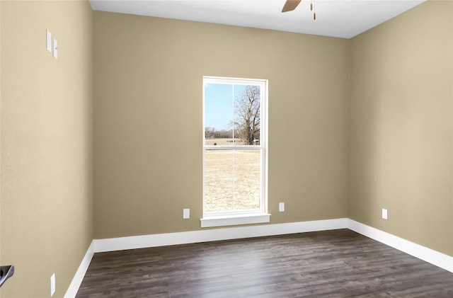 spare room featuring dark wood-type flooring, plenty of natural light, and ceiling fan