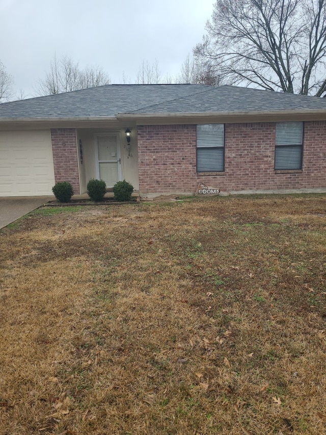 single story home featuring a garage and a front yard