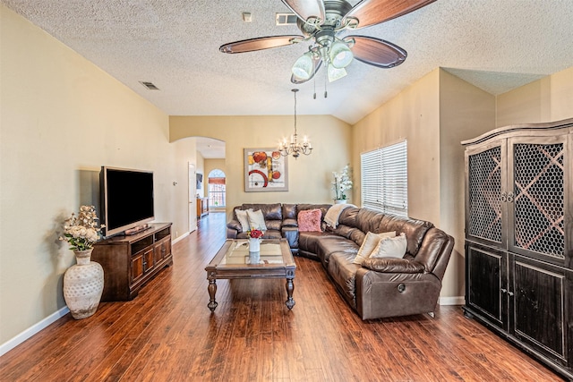 living room featuring lofted ceiling, ceiling fan with notable chandelier, a textured ceiling, and dark hardwood / wood-style flooring