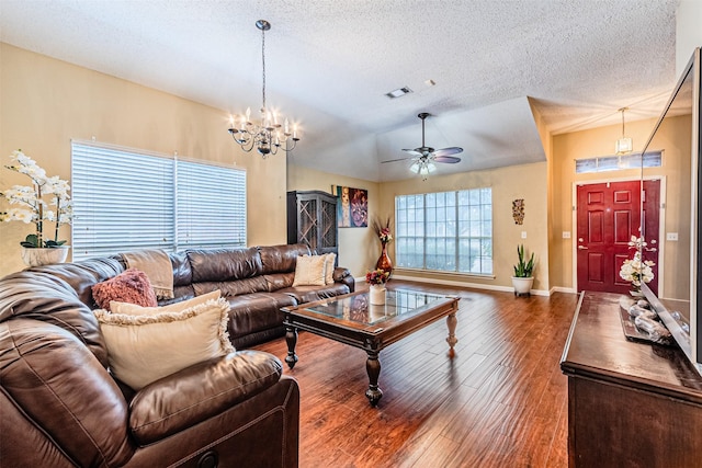 living room featuring dark wood-type flooring, ceiling fan with notable chandelier, vaulted ceiling, and a textured ceiling