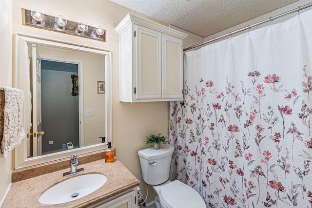 bathroom with vanity, walk in shower, a textured ceiling, and toilet