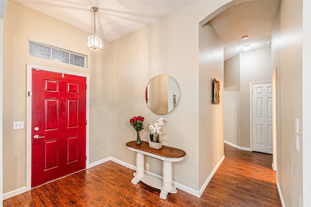 foyer entrance with dark wood-type flooring and a textured ceiling