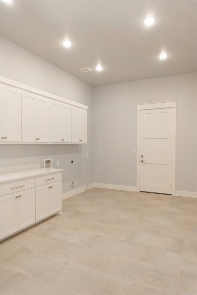 clothes washing area featuring cabinet space, baseboards, gas dryer hookup, hookup for a washing machine, and hookup for an electric dryer