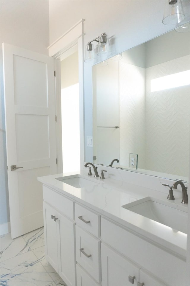 full bathroom featuring marble finish floor, double vanity, and a sink