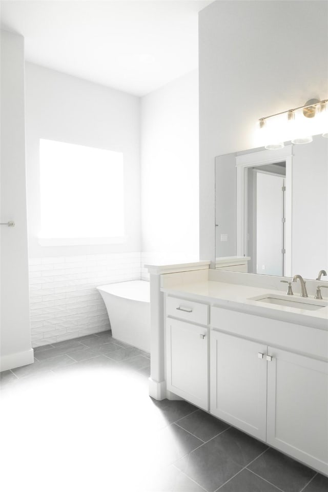 full bathroom featuring a soaking tub, tile patterned floors, and vanity