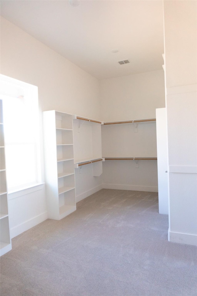 walk in closet featuring light colored carpet