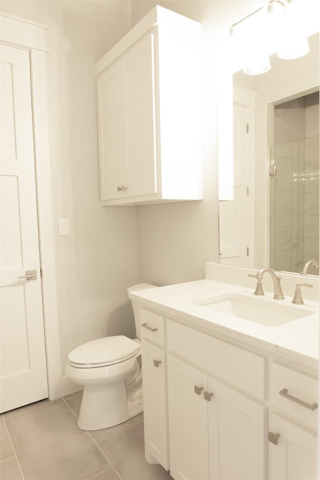 bathroom featuring toilet, a shower stall, tile patterned flooring, and vanity