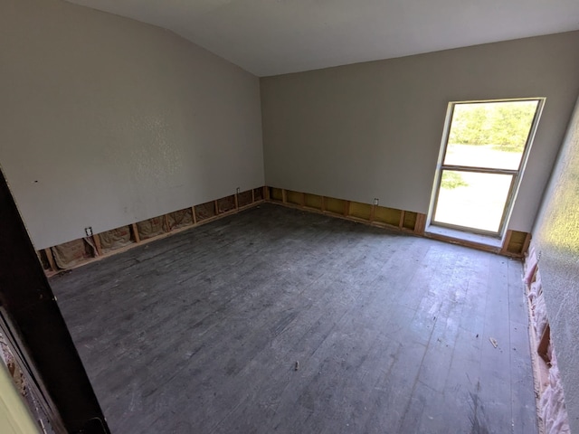 unfurnished room with wood-type flooring and lofted ceiling
