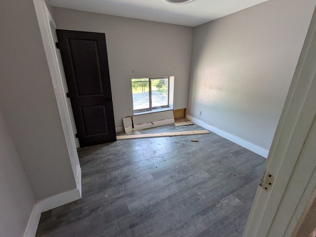 spare room with baseboards and hardwood / wood-style flooring