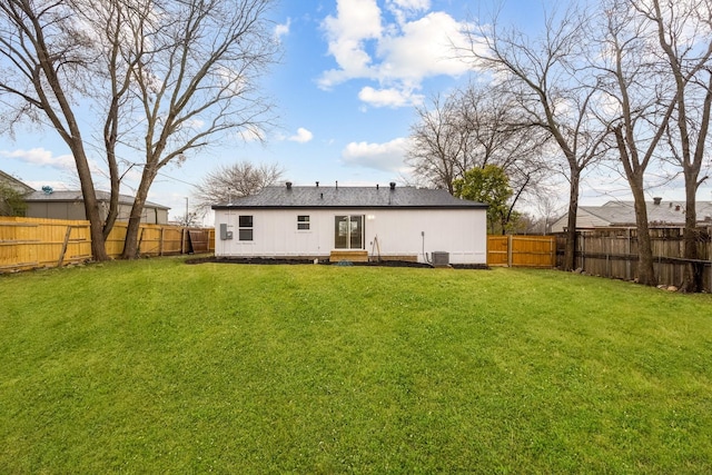 back of house featuring central AC unit and a yard