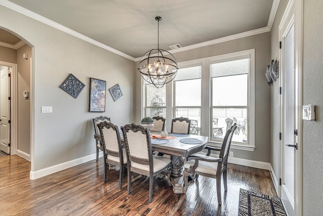 dining space featuring crown molding, dark hardwood / wood-style flooring, and an inviting chandelier