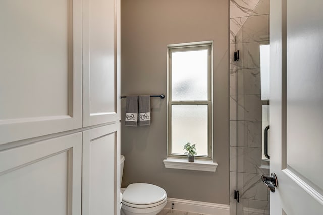 bathroom with a shower with door and toilet