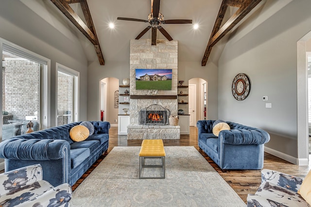 living room with hardwood / wood-style floors, a fireplace, vaulted ceiling with beams, and ceiling fan