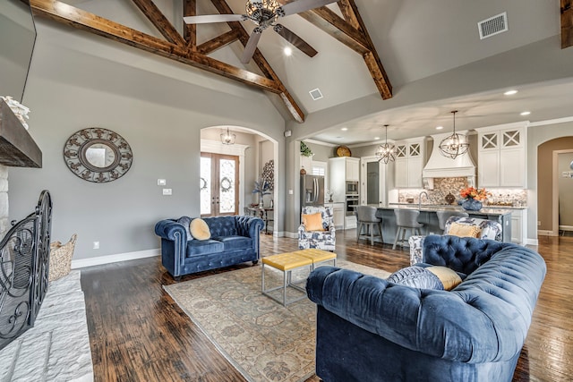 living room featuring french doors, dark wood-type flooring, high vaulted ceiling, beamed ceiling, and ceiling fan with notable chandelier