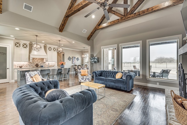 living room featuring dark hardwood / wood-style flooring, high vaulted ceiling, ceiling fan with notable chandelier, and beam ceiling